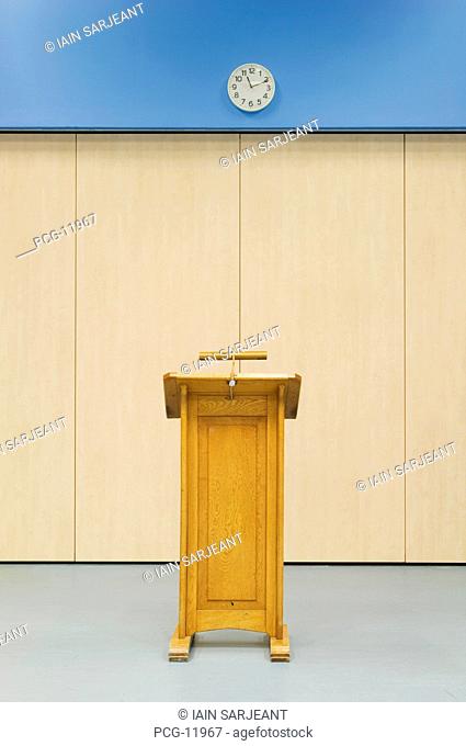 Wooden lectern and clock in the main hall of a modern secondary school