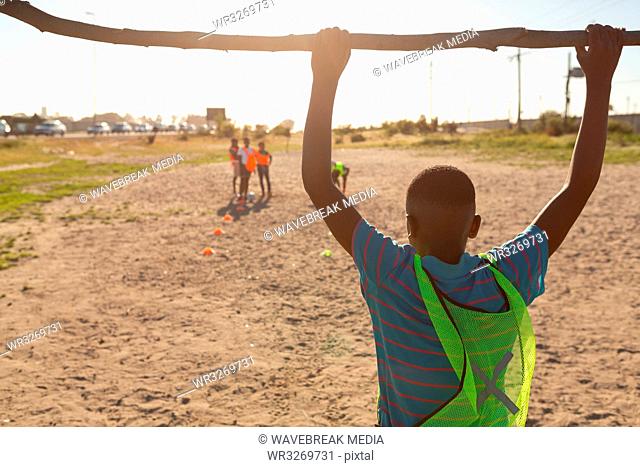 Boy hanging on goal post in the ground