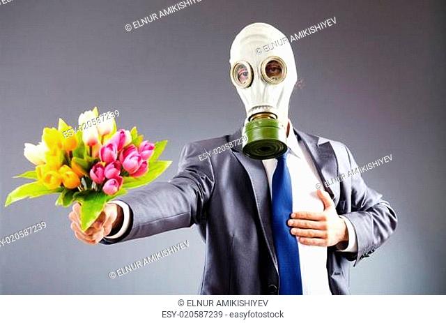 Businessman with gas mask and flowers