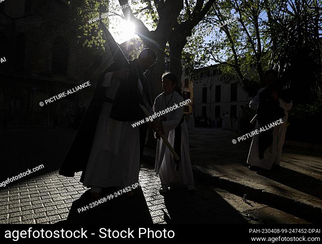 07 April 2023, Spain, Palma: Penitents Jose and Carla fix their clothes before participating in the procession ""Sant Enterrament"" (Holy Burial) in Palma