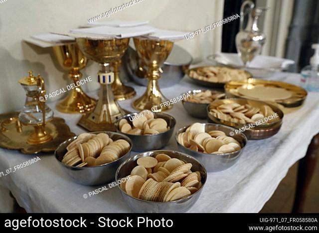Catholic mass. Eucharist table with the liturgical items. Communion wafers. France