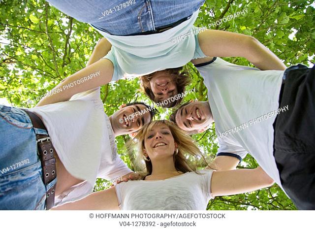Four young people smiling down at the camera, Germany, Europe