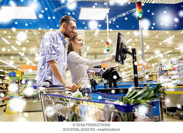 couple buying food at grocery self-checkout