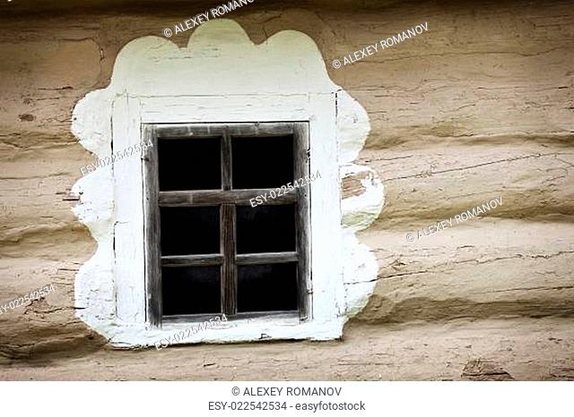Window of ancient Ukrainian hut. Clay covered wall