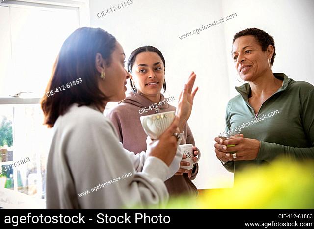 Mother and young adult daughters talking at home
