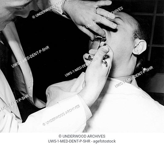 United States: c. 1933 A patient getting shot of novocain before having a tooth extracted by a dentist