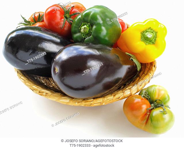Basket with aubergines, tomatoes and peppers