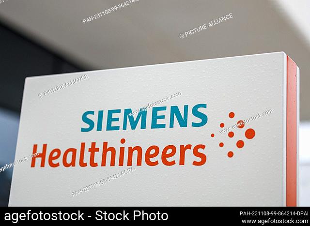 07 November 2023, Bavaria, Erlangen: The logo and lettering of the medical technology group Siemens Healthineers stands on a stele in front of a company...