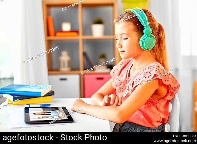 girl with tablet pc having online class at home