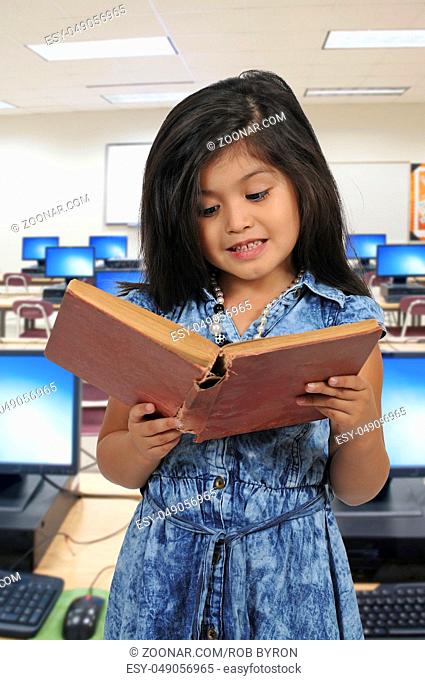 Little girl holding or reading a library book