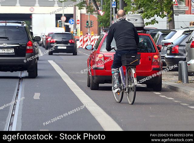 29 April 2020, Berlin: A passenger car is parked on a cycle path in the Köpenick district and obstructs cyclists who have to avoid the vehicle
