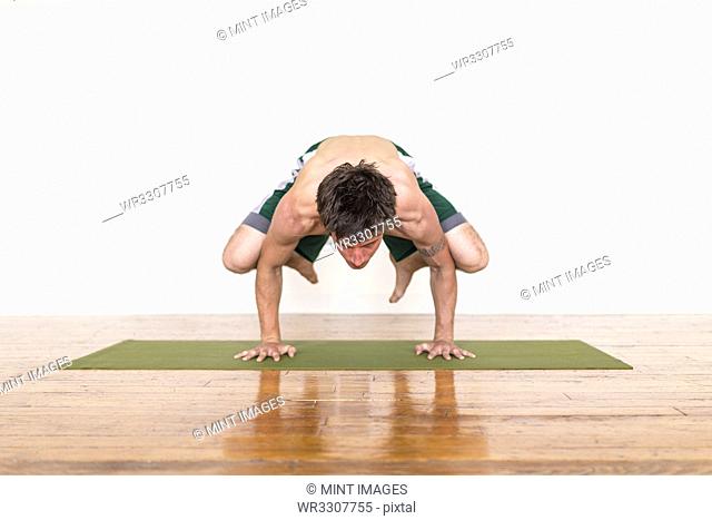 Man practicing yoga in studio