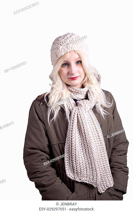Pretty young blonde woman in winter clothes with knitted hat and scarf