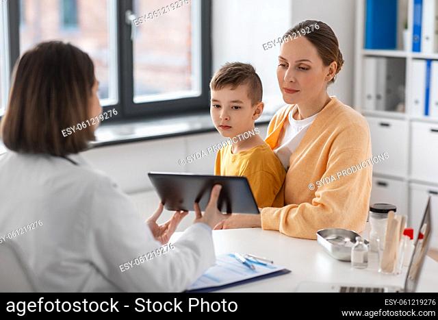 mother, son and doctor with tablet pc at clinic
