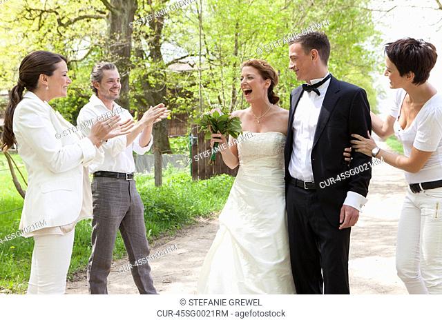 Friends applauding newlywed couple