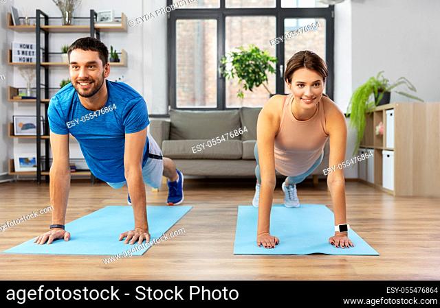 happy couple exercising at home