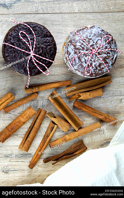 Chocolate ginger biscuits bandaged with red-and-white thread with cinnamon laid out on a wooden table