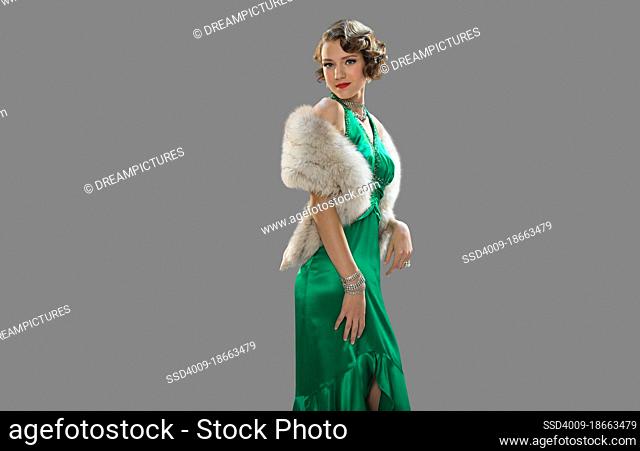Woman dressed in elegant clothing for Halloween party against gray background