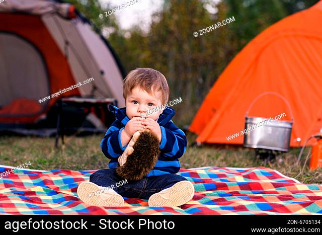 little boy playing with a teddy bear in the grass
