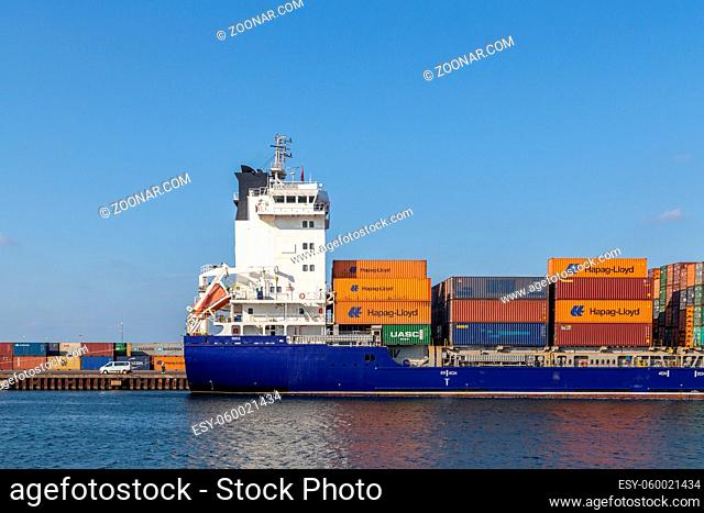 Copenhagen, Denmark - April 18, 2018: Side view of a container cargo ship anchored in the harbor