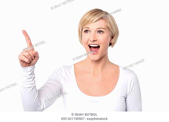 Surprised woman pointing her finger to upwards
