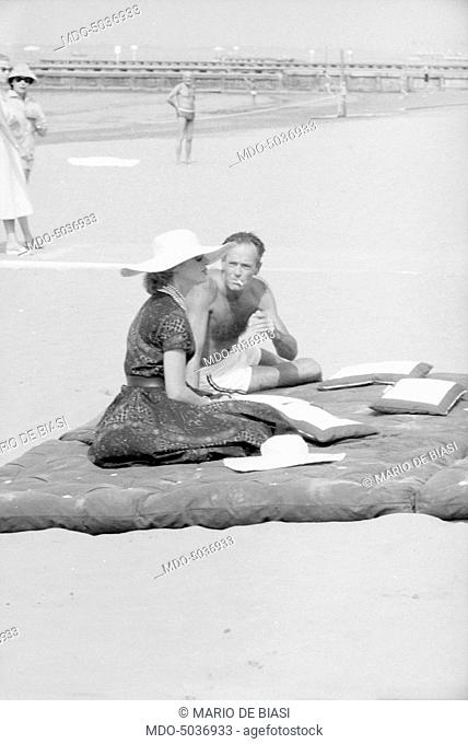American actor Henry Fonda and his wife, Italian baroness Afdera Franchetti, on the beach during the XVIII Venice International Film Festival