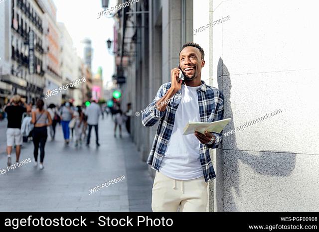 Tourist with map talking on smart phone in city