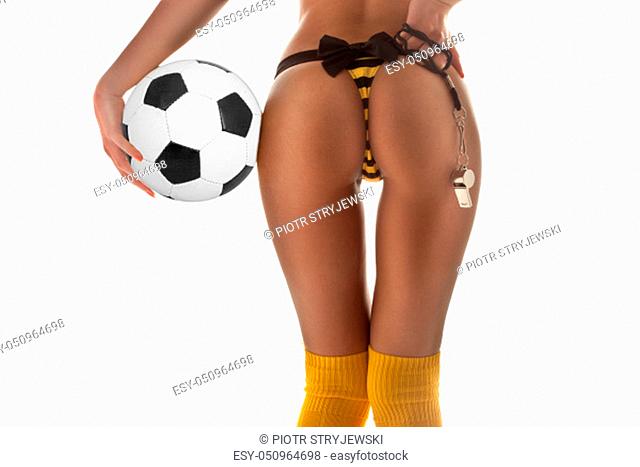 Closeup of sexy female soccer player. Back view of woman in panties and yellow knee socks holding ball and whistle over white wall background
