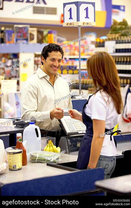 Man paying by credit card at supermarket check-out