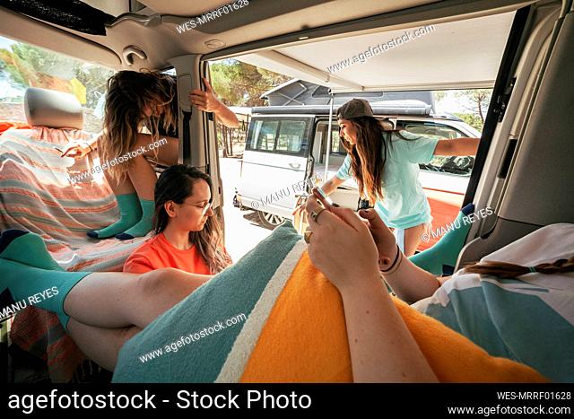 Woman using mobile phone in camper van