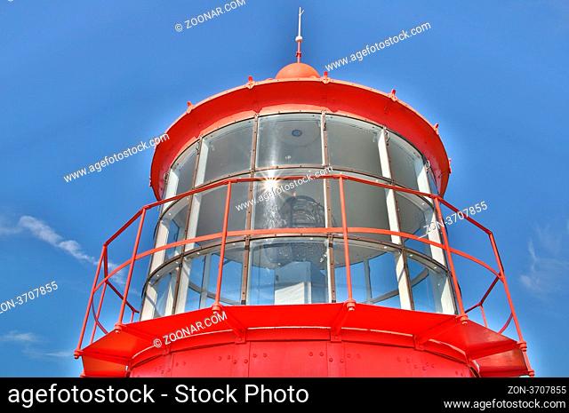 Red lighthouse seen majestic on clear blue sky