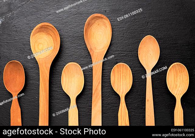 empty wooden spoons on a a black background, top view, set