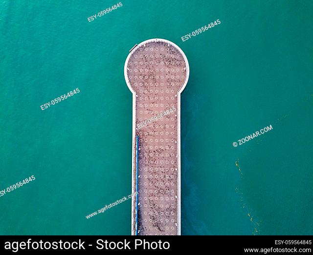 Aerial view of small pier on teal sea water