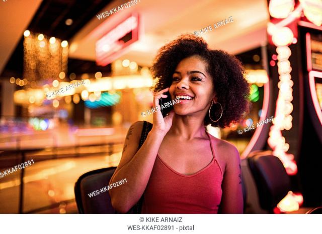 USA, Nevada, Las Vegas, portrait of happy young woman on cell phone in a casino