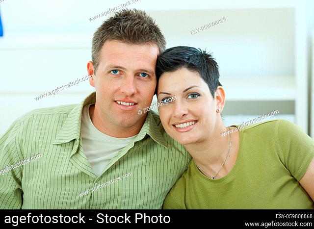 Happy young love couple cuddling at home, smiling