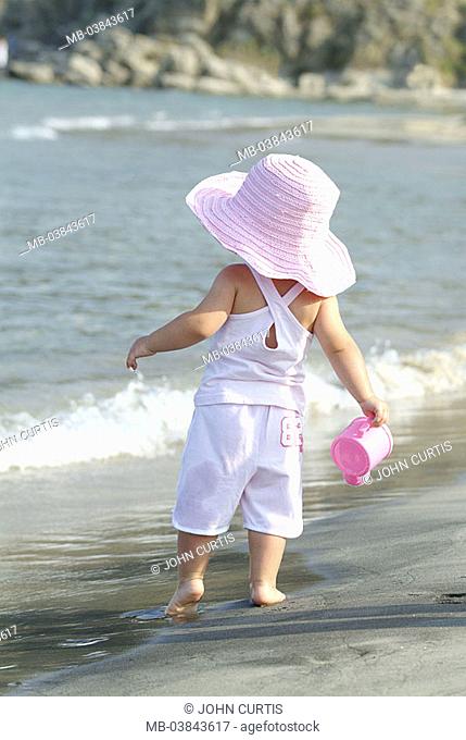 Toddler, watering can, back-opinion, beach, sea, holds goes, people, child, girls, 1-2 years, quite-bodies, barefoot, hat, sunhat, big, headgear, shorts, Shirt
