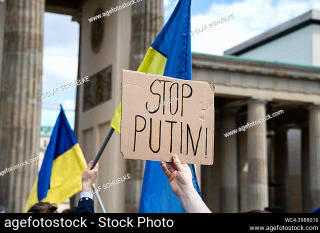 Berlin, Germany, Europe - A protester holds up a sign reading ""Stop Putin!"" and demonstrates along with other activists at a demonstration at the Brandenburg...