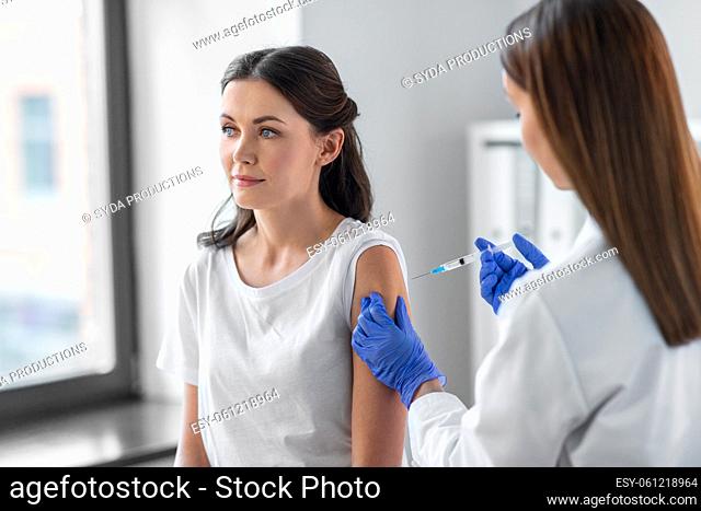 female doctor with syringe vaccinating patient