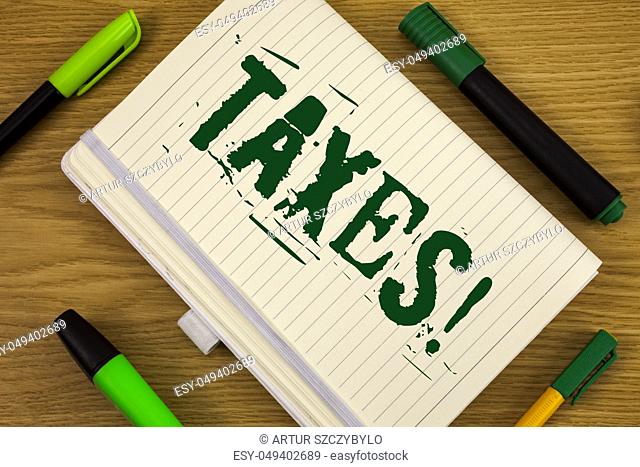 Text sign showing Taxes Motivational Call. Conceptual photo Money demanded by a government for its support written Notebook Book the wooden background Pen and...