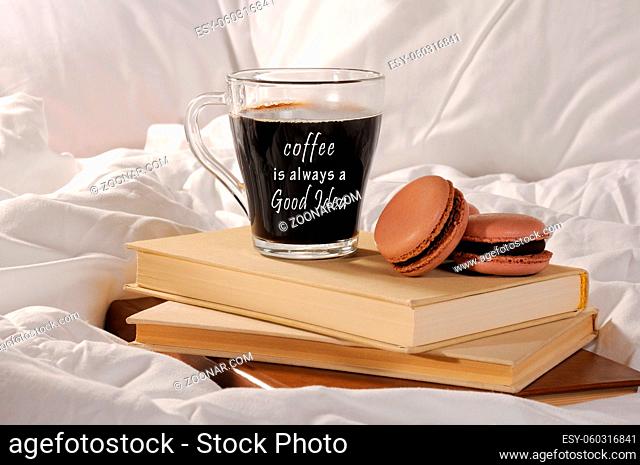 Morning cup of coffee with chocolate cakes Macaroons, on a pile of books in bed. Coffee is always a Good idea
