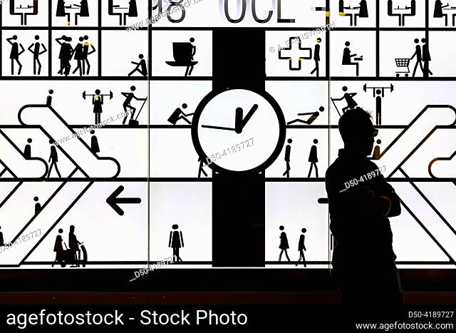 Stockholm, Sweden A man stands at an illuminated board at the Central Train Station with moving symbols