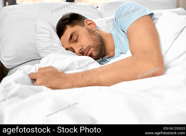 man sleeping in bed at home