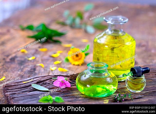 Alternative medicine with essential oils, bottle potion and flowers on a wooden table