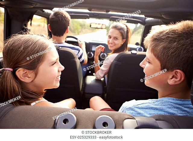 Parents Taking Children On Trip In Open Top Car
