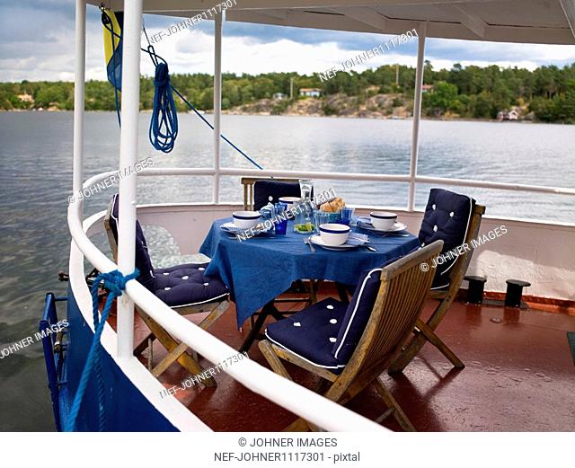 Table, chair and place setting on bow of boat