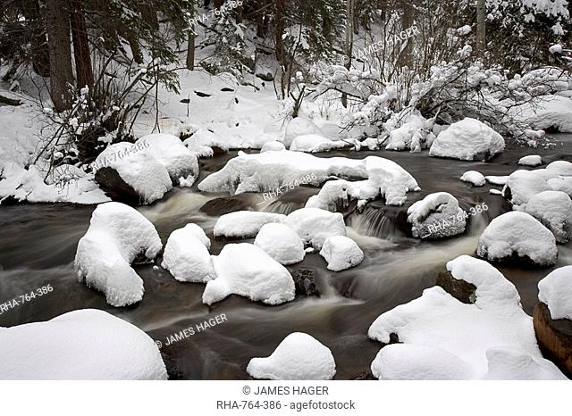 Snow-covered boulders and flowing creek, Glacier Creek, Rocky Mountain National Park, Colorado, United States of America, North America