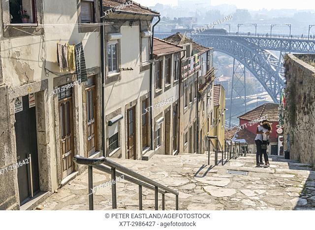 Steps leading down to the River Douro waterfront in the Ribeira district of Porto, Portugal. with the Dom Luis I Bridge in background
