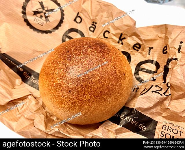 PRODUCTION - 28 November 2023, Brandenburg, Potsdam: On a paper bag lies a bread roll called ""Ossi"" in the bakery of Tobias Exner from Beelitz in Brandenburg