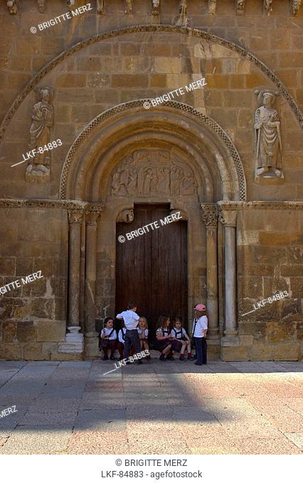 Side entrance of church, Real Basílica de San Isidoro with children sitting on the steps, Leon, Castilla Leon, Spain