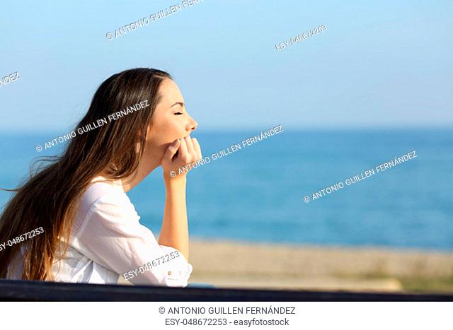 Side view portrait of a woman relaxing mind on the beach